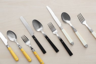 Çatal bıçak takımı hafif ahşap arka plan üzerinde düz dizi yatıyordu