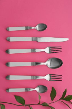 Düz renkli arka plan üzerinde çatal bıçak seti yatıyordu