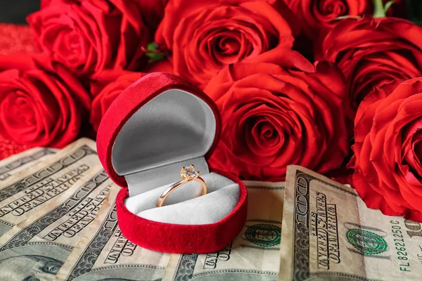 Box with wedding ring on dollars. Marriage of convenience
