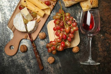Tatlı üzüm, kadeh kırmızı şarap ve tablo snacks ile kompozisyon