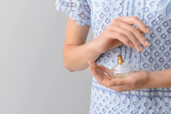 Frau Mit Einer Flasche Parfüm Auf Grauem Hintergrund Nahaufnahme — Stockfoto