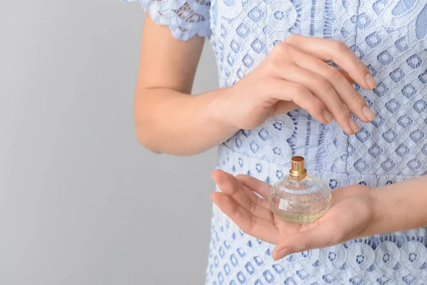 Frau Mit Einer Flasche Parfüm Auf Grauem Hintergrund Nahaufnahme — Stockfoto