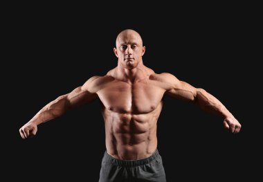 Koyu arka plan üzerinde kas vücut geliştirmeci