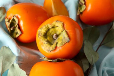 Sweet ripe persimmons on table, closeup clipart