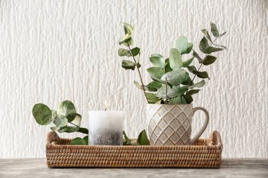 Mum ve okaliptüs dalları masaya yanma ile hasır tepsi