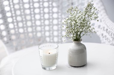 Yanan mum ve masaya çiçek vazo