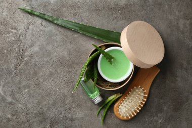 Aloe yaprakları ve gri arka plan üzerinde saçlar için doğal kozmetik düz yatıyordu kompozisyonu