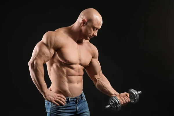 Muskulöser Bodybuilder Mit Hantel Auf Dunklem Hintergrund — Stockfoto