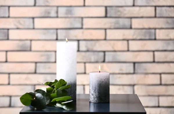 Brennende Kerzen Auf Tisch Nahe Ziegelmauer — Stockfoto