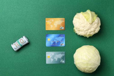 Taze lahana ile dolar ve kredi kartları düz renkli arka plan üzerinde yatıyordu