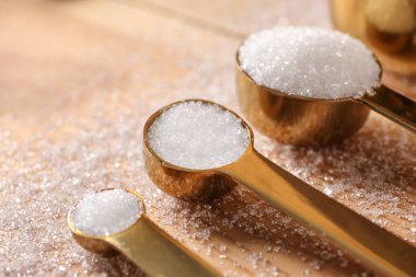 Ahşap arka plan üzerinde rafine şeker ile kaşık