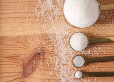 Ahşap arka plan üzerinde rafine şeker ile kaşık