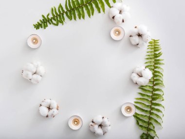 Yanan mumlar, pamuk çiçek ve beyaz arka plan üzerinde tropikal yaprak çerçeve yaptı