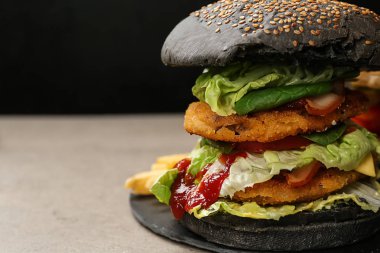 Lezzetli hamburger, masada siyah çörek, yakın plan.