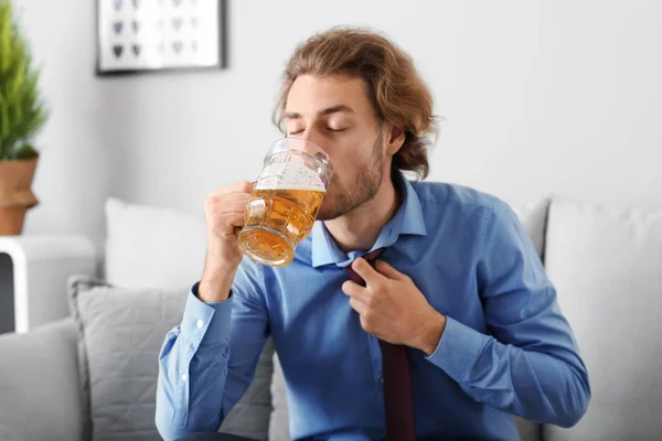 Young man drinking beer at home. Alcoholism concept