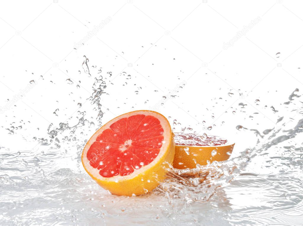 Fresh grapefruit with splashing water on white background