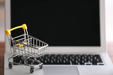 Laptop, closeup küçük el arabası. Online alışveriş