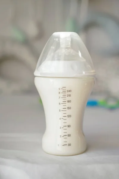 Feeding bottle of baby formula on bed