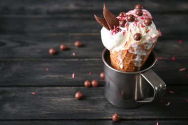 Gözleme koni koyu ahşap masa üzerinde metal Kupası'nda lezzetli dondurma ile