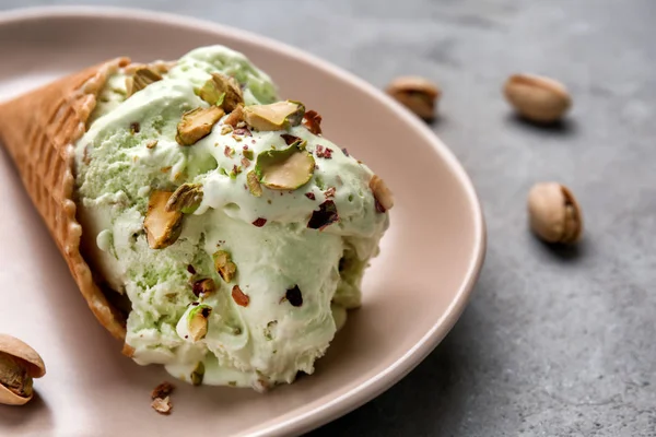 おいしいアイスクリームとプレート クローズ アップのピスタチオとワッフル コーン — ストック写真