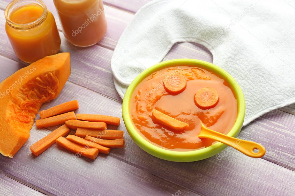 Bowl with healthy baby food on kitchen table