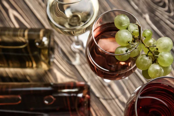 Gözlük ve ahşap masa üzerinde farklı şarap şişeleri