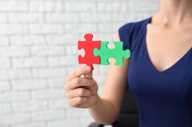 Tuğla duvar arka plan üzerinde renkli bulmacanın parçaları kadınla