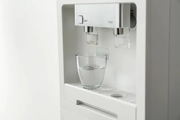 Modern water cooler with glass on white background