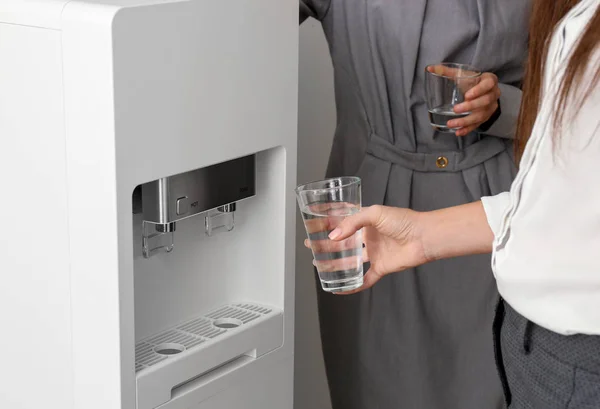 Women having break near water cooler in office