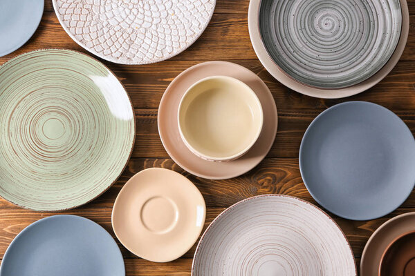 Набор чистой посуды на деревянном фоне, вид сверху
