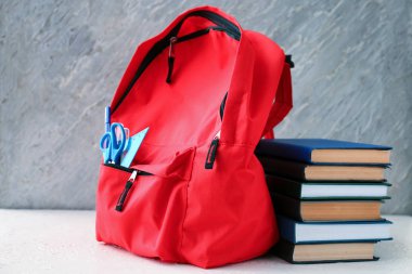 Okul malzemeleri ile beyaz masaya sırt çantası