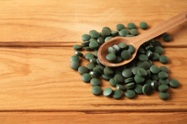 Ahşap masa spirulina tablet kaşıkla