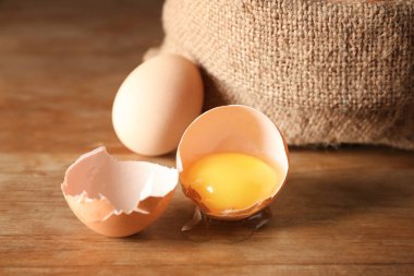 Kırık ve ahşap masa üzerinde bütün tavuk yumurta