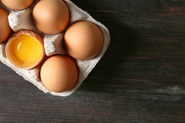 Kırık ve bütün tavuk yumurta karton Pack koyu ahşap tablo