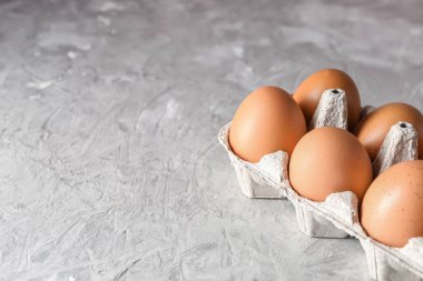 Gri masaya karton paketi ile çiğ tavuk yumurta