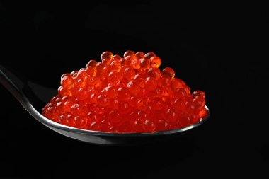 Lezzetli kırmızı havyar koyu arka plan üzerine kaşıkla