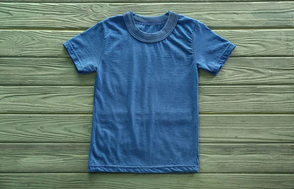 木製の背景の空の青い シャツ — ストック写真