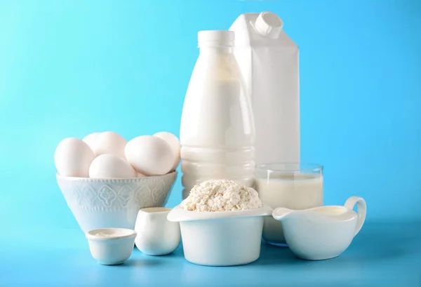 Different milk products with eggs on color background