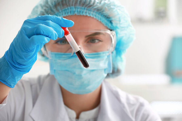 Woman working with blood sample in laboratory