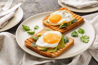 Plaka üzerinde lezzetli kızarmış yumurtalı kızarmış ekmek
