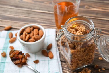Granola ve ahşap masa üzerinde fındık ile jar