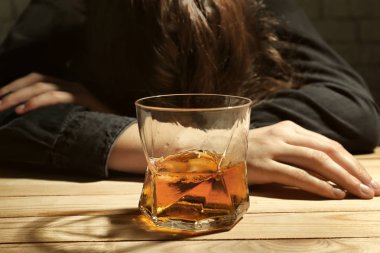 Viski ahşap masa ve bilinçsiz sarhoş kadın cam çubuk