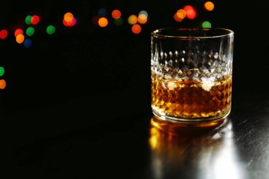 Karanlık arka planda bir bardak viski.