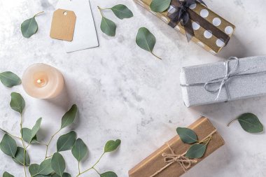 Mum, Okaliptüs yaprakları ve hediye kutuları ışık arka plan üzerinde yanan ile kompozisyon