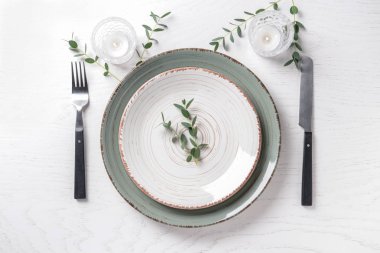 Okaliptüs şube ve dishware hizmet beyaz tablo ile yanan mumlar