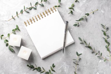 Okaliptüs şube ve gri arka plan üstünde defter ile yanan mumlar