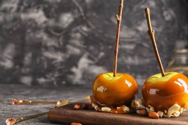 Ahşap tahta üzerinde ağaç dalları ile lezzetli karamel elmalar