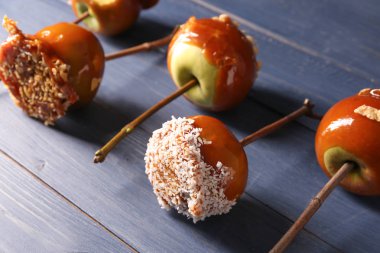 Lezzetli karamelli elma renk ahşap masa üzerinde ağaç dalları ile