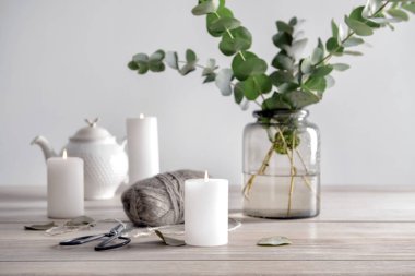 Yanan mumlar ve ahşap masa dallarda okaliptüs vazo