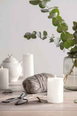 Yanan mumlar ve ahşap masa dallarda okaliptüs vazo